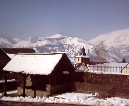 vue sur un lavoir depuis le haut du village, les montagne enneigées sont en fond
